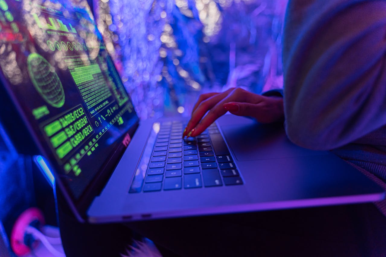 Person typing on laptop with cybersecurity data on screen, highlighting password vulnerabilities