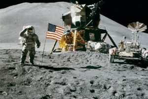 Astronaut on the Moon near lunar module and rover, symbolizing future lunar nuclear reactor exploration