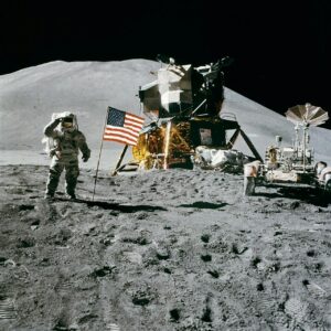 Astronaut on the Moon near lunar module and rover, symbolizing future lunar nuclear reactor exploration