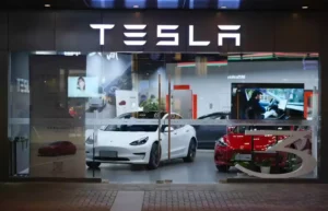 Tesla showroom with electric vehicles representing AI strategy shift after Dojo shutdown