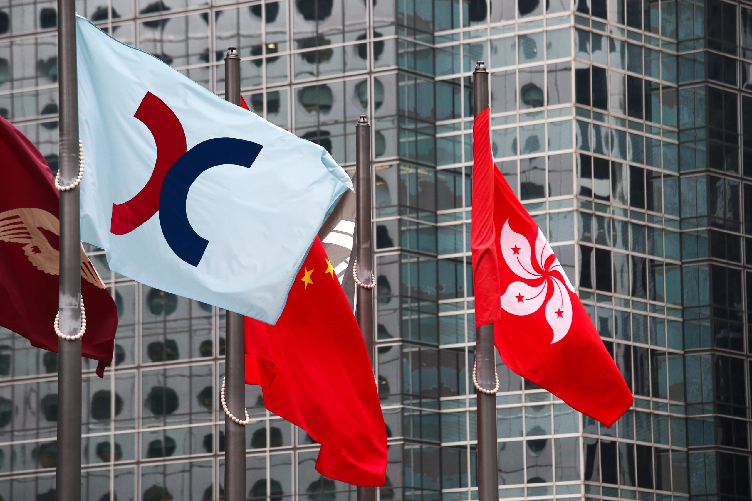 Flags of China and Hong Kong displayed outside a commercial building, symbolizing financial markets and regional economic activity.