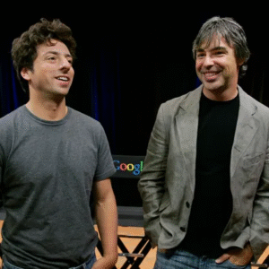 Two Google co-founders on stage during a public appearance amid discussion on California billionaire tax and residency shifts