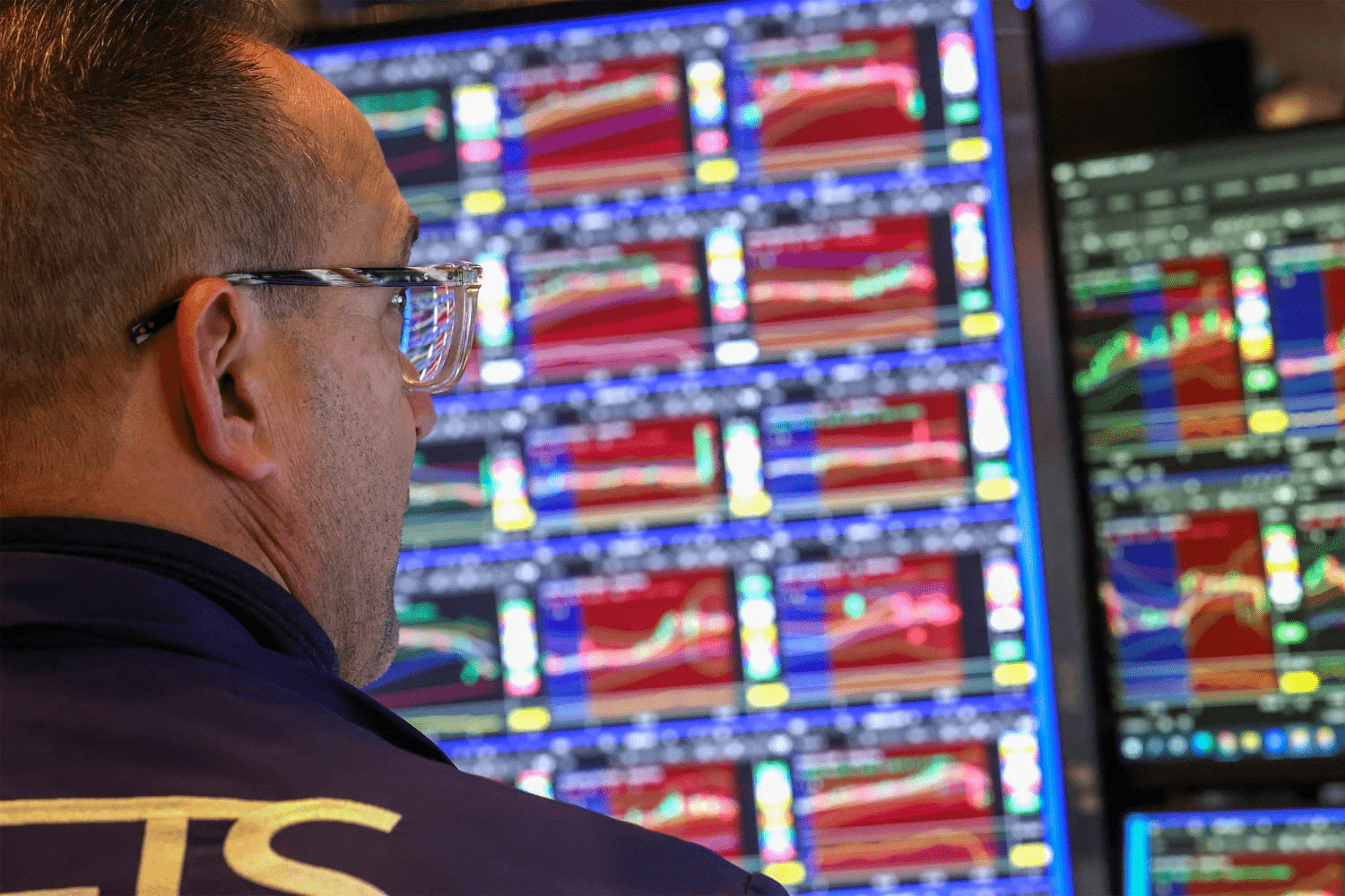 Trader analyzing market screens reflecting Magnificent 7 stock performance divergence in 2025