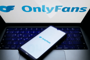 OnlyFans logo displayed on a smartphone and laptop screen, representing the platform amid talks of a majority stake sale to Architect Capital.