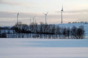 Wind turbines connected to Poland’s power grid across snowy fields, highlighting critical energy infrastructure