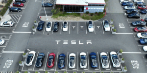 Tesla vehicles parked at a dealership as the company reports a 9% annual sales decline in 2025 amid rising global EV competition.