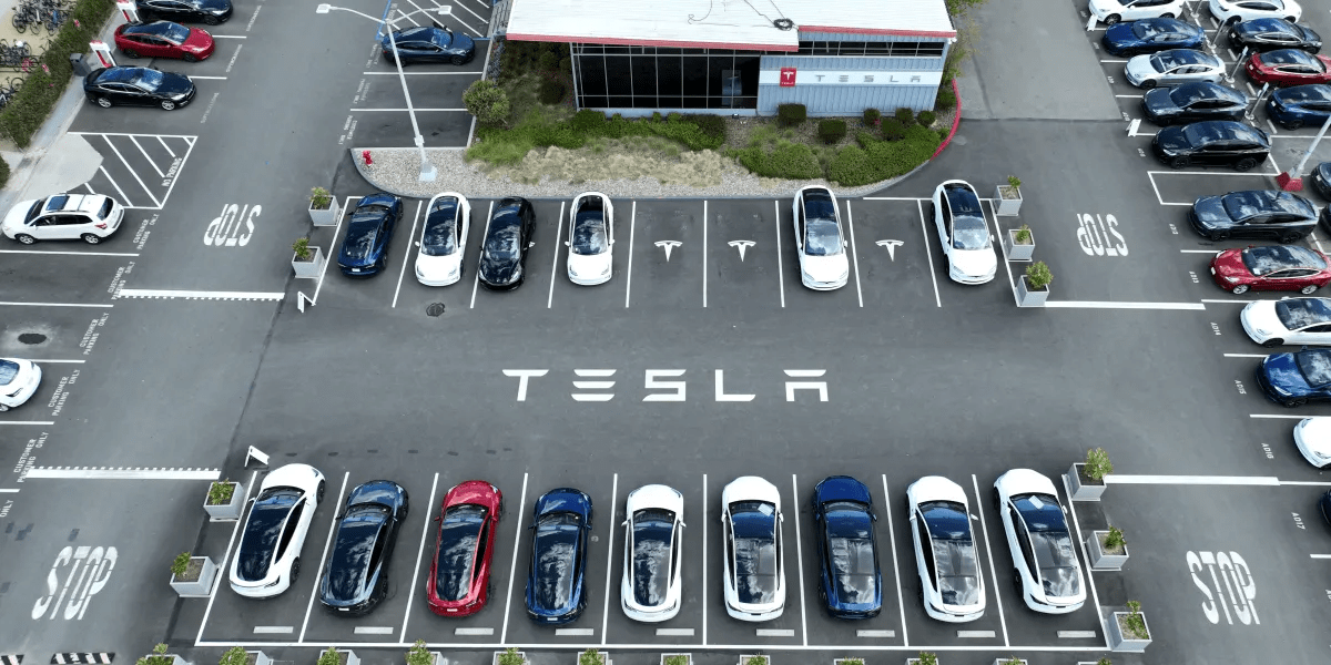 Tesla vehicles parked at a dealership as the company reports a 9% annual sales decline in 2025 amid rising global EV competition.